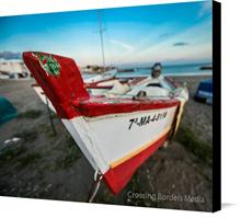 Canvas print of Boat on the beach of Malaga, Spain by the artist Crossing Borders Media